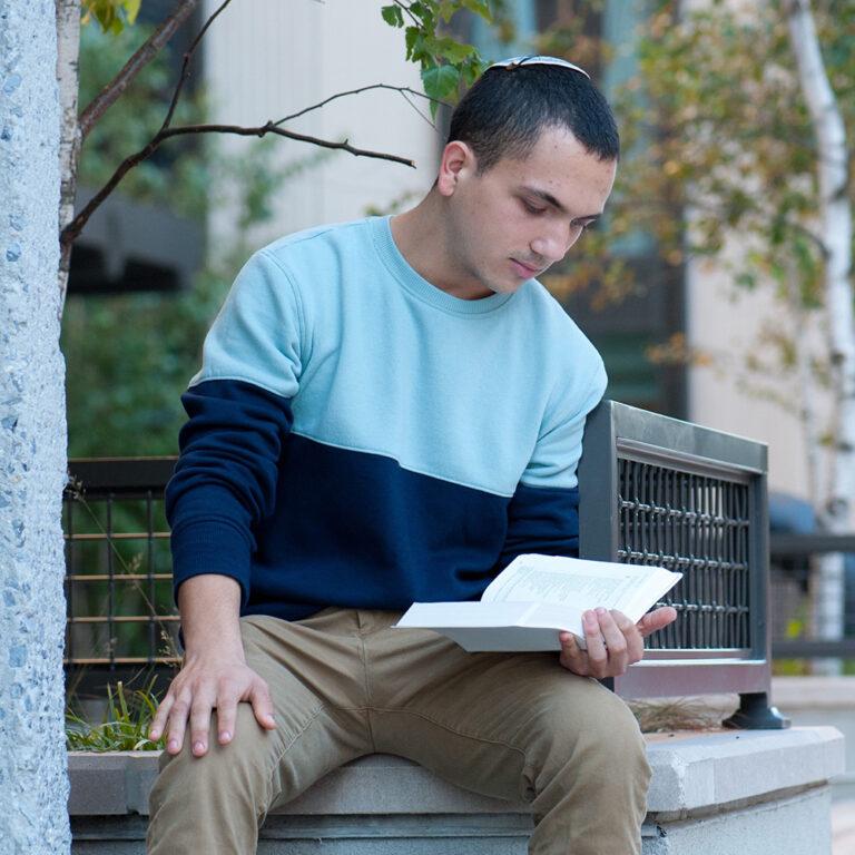 Male-Student-Looking-at-Book-2021
