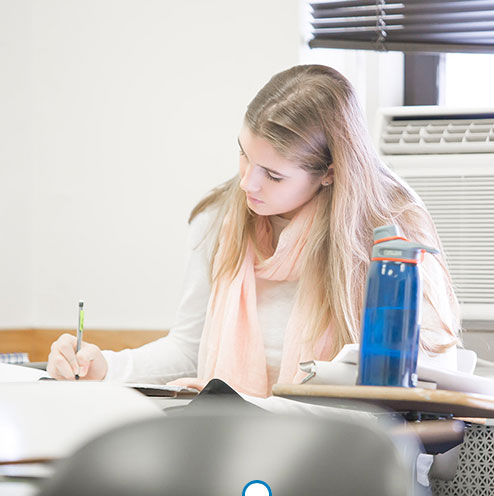 woman-student-writing-at-desk
